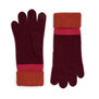 A pair of winter gloves in dark purple wool, with a bright red and magenta cuff.